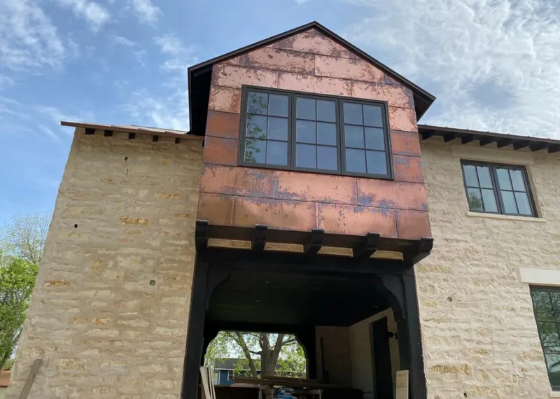 Copper metal panel facade on a stone building for Roof Repair in Lawton